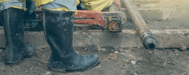 Someone in rain boots standing in mud. 