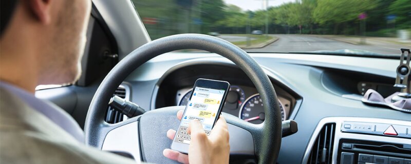 A man texting while driving.