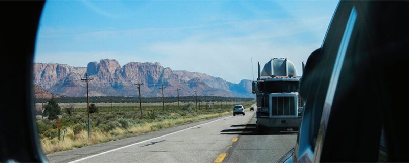 Photo of a semi driving on a road.