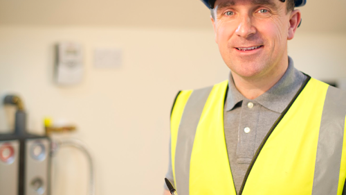 A man in a hard hat and yellow vest.