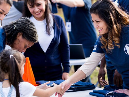 Volunteers having people sign in and getting t-shirts.