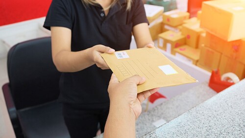 office front desk attendant receiving mail from a courier