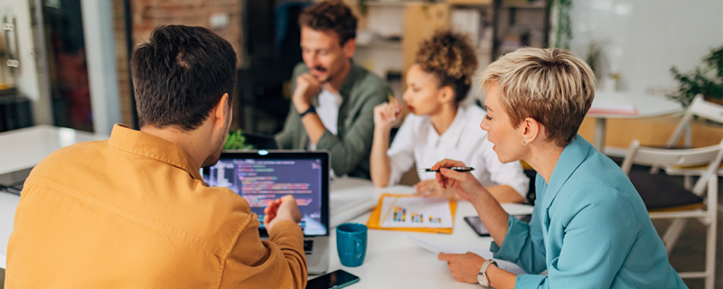 Employees talking around a table.