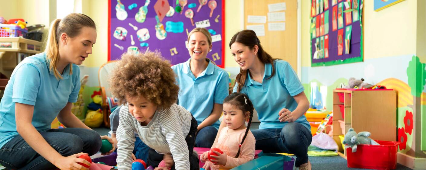 Teachers/daycare providers playing with two kids.
