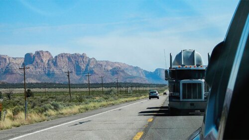 Photo of a semi driving on a road.