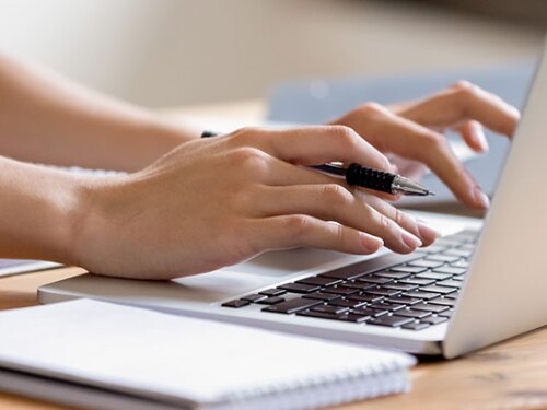 A person typing on a laptop. 