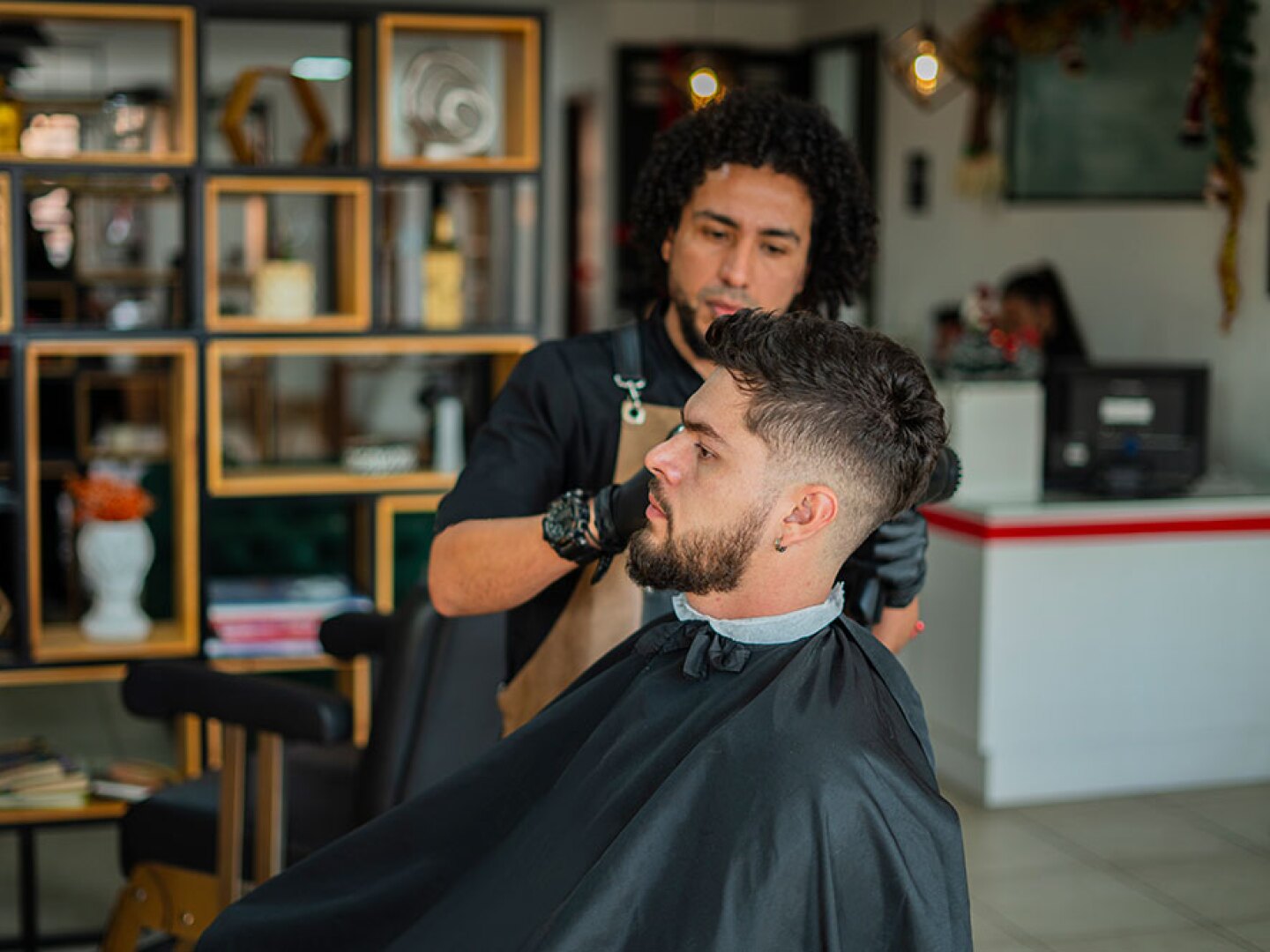 Barber trimming a customer's hair.