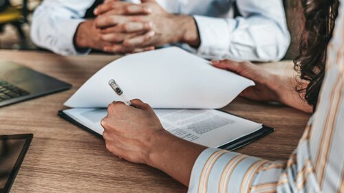 A woman signing paperwork.