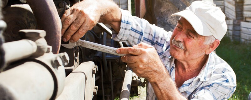 A farmer working on farm equipment. 