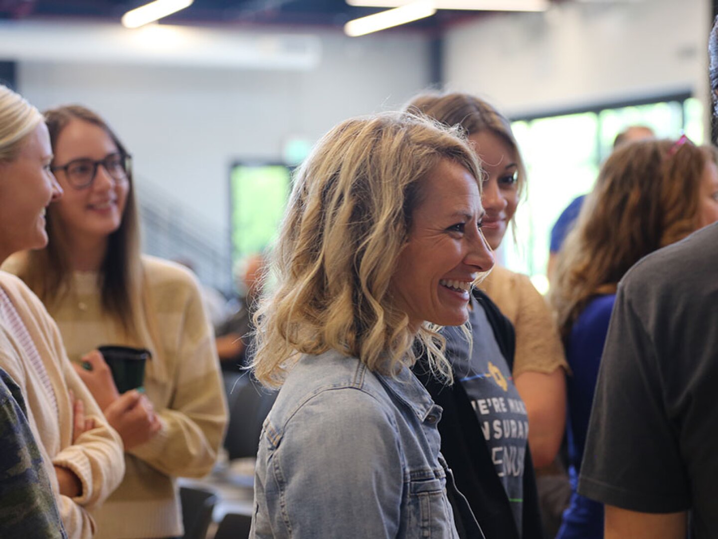 A photo of secura employees standing together talking and laughing. 