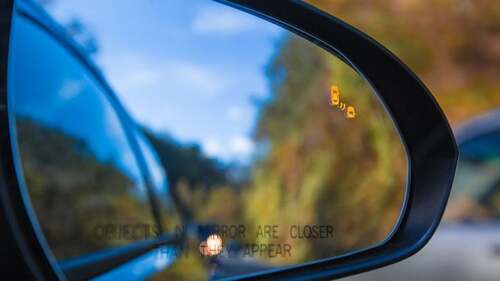 Photo of a cars side mirror.