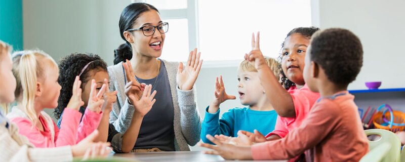 A teacher/daycare provider teaching her students how to count.