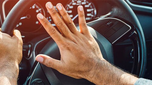 Someone pressing the horn on his steering wheel.