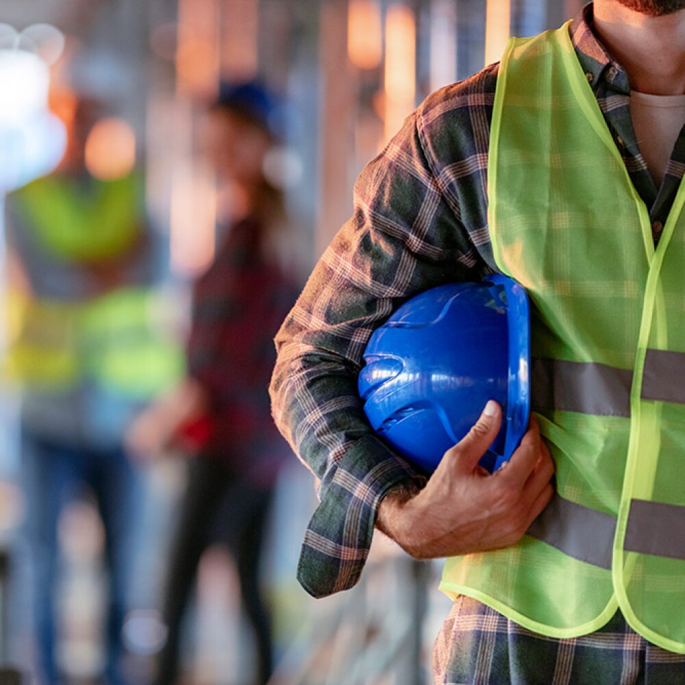 A man holding a helmet on the side of him.