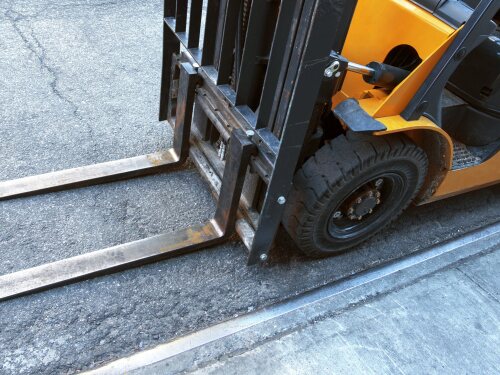 close up view looking down at a forklift parked at the side of a loading dock