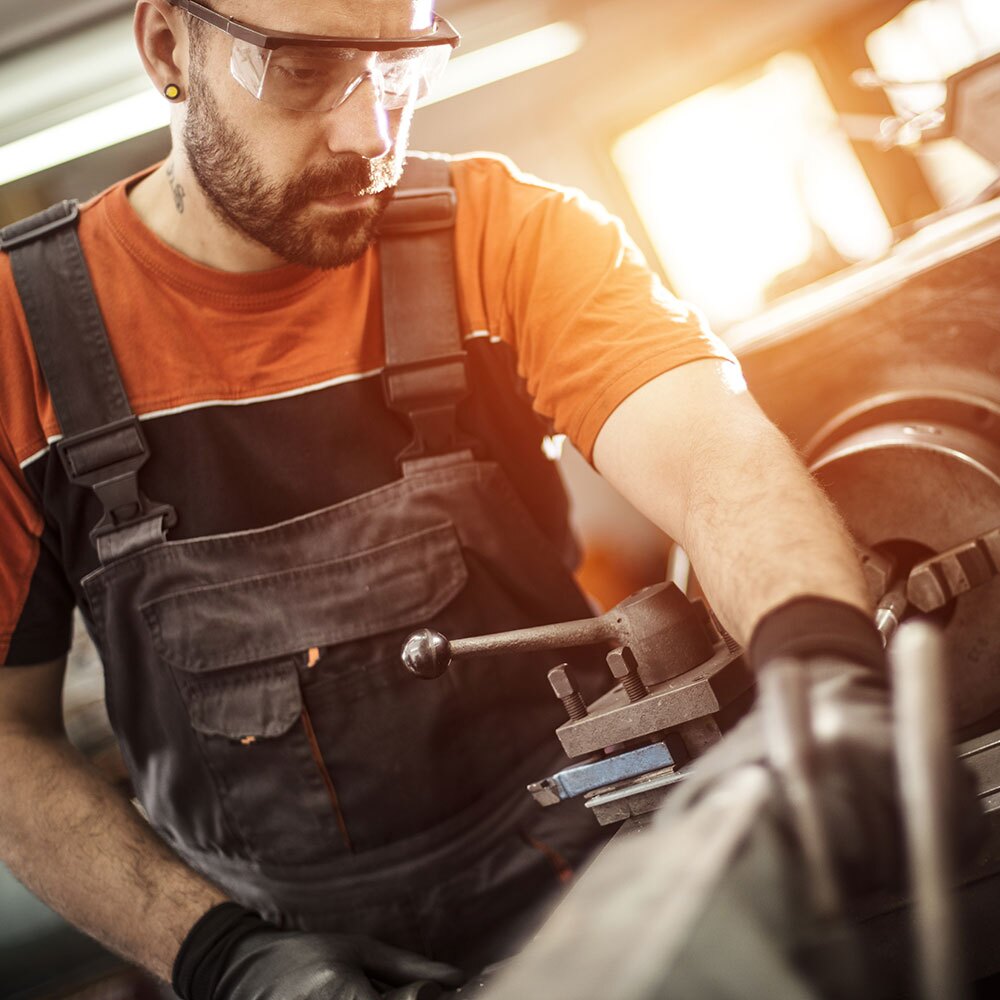 A metal worker working with protective eye glasses on. 