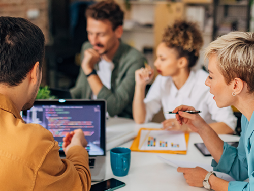 Employees talking around a table.