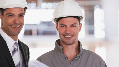 two commercial general contractors with hard hats on