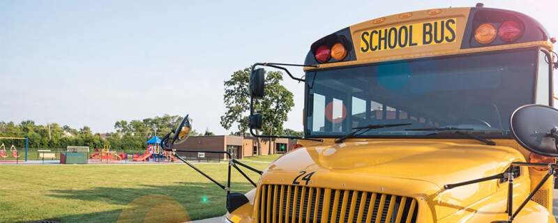 School bus parked in front of a school.