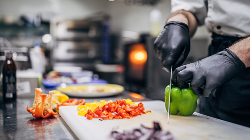 A chief cutting peppers.