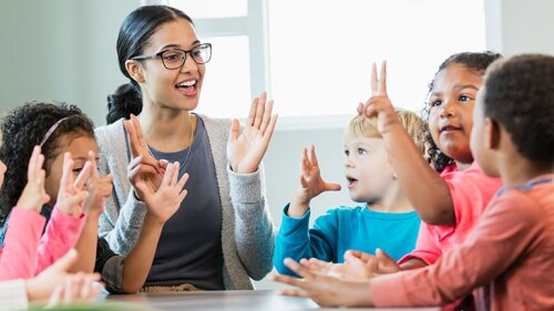 A teacher/daycare provider teaching her students how to count.