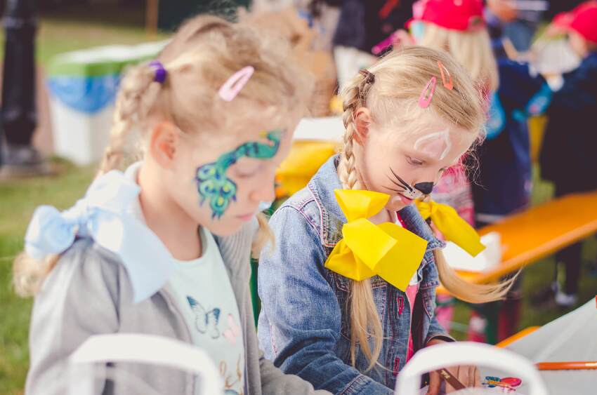 Two girls with faces painted at outdoor event