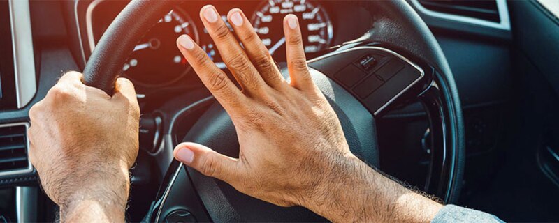 Someone pressing the horn on his steering wheel.