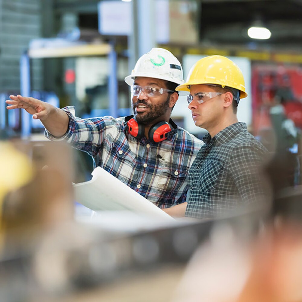 Factory worker showing a risk manager around the facility. 