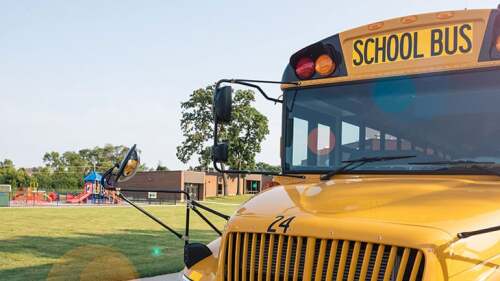 School bus parked in front of a school.