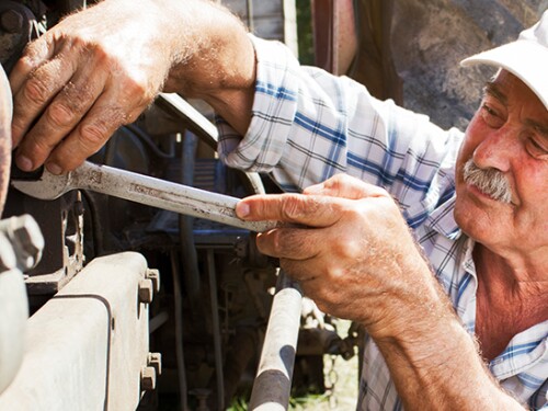 A farmer working on farm equipment.