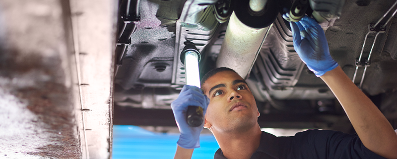 Mechanic inspecting a car exhaust