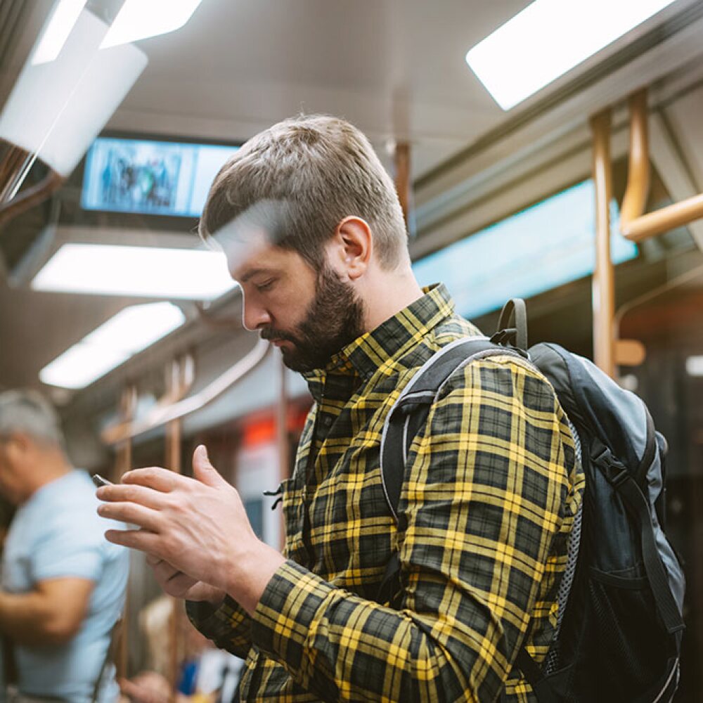 young-man-working-on-phone-while-commuting-to-work.jpg