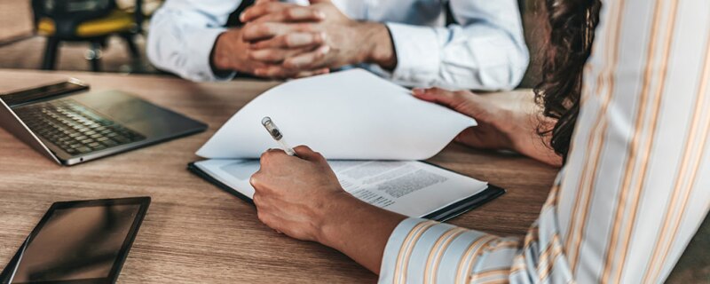 A woman signing paperwork. 