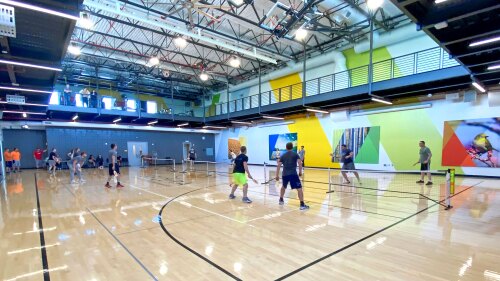 Secura associates playing pickleball in the home office gym. 