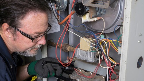 A man looking at a furnace.