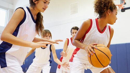girls basketball teams competing on the court.